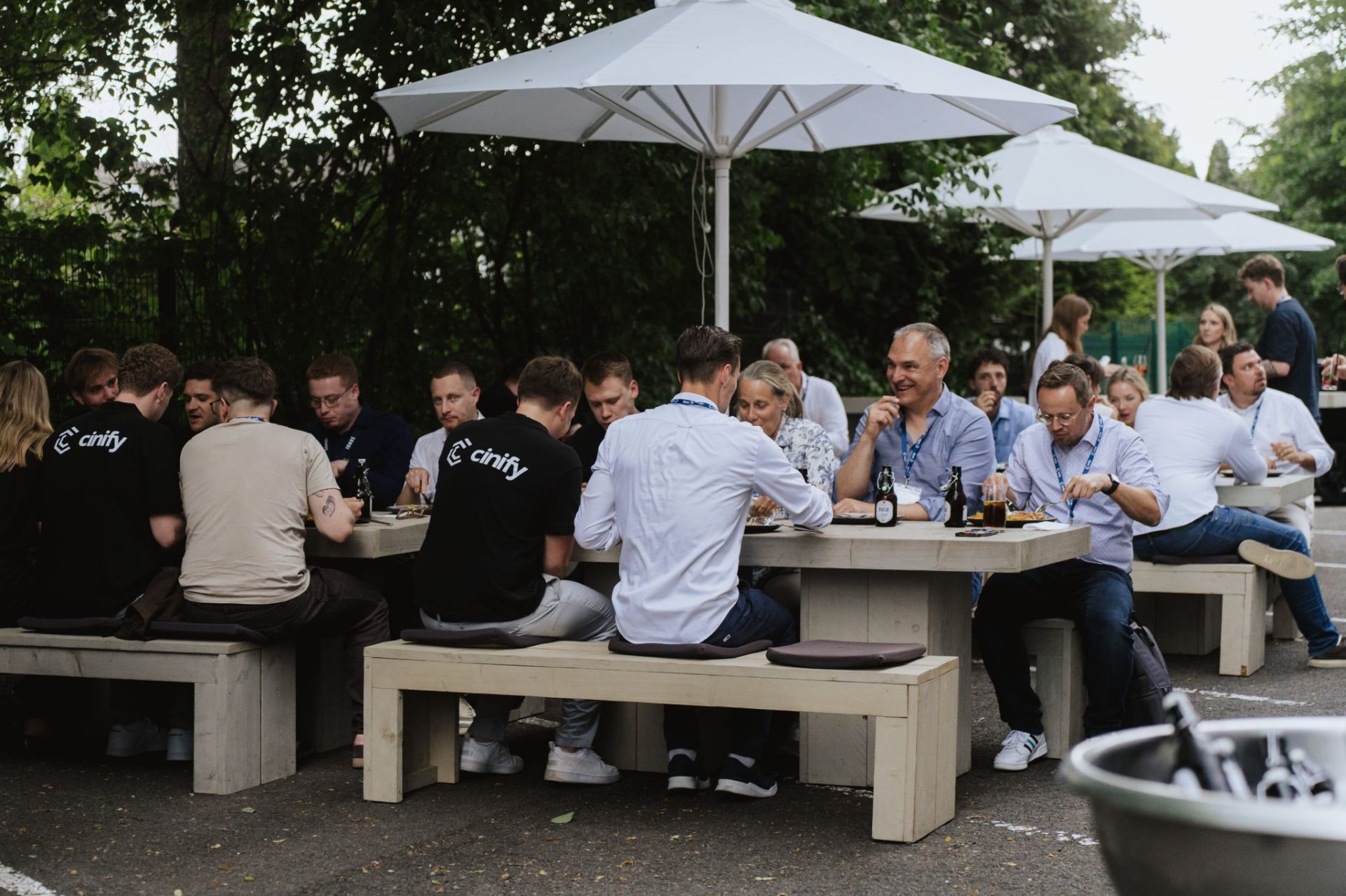 Networking-Dinner unter weißen Sonnenschirmen